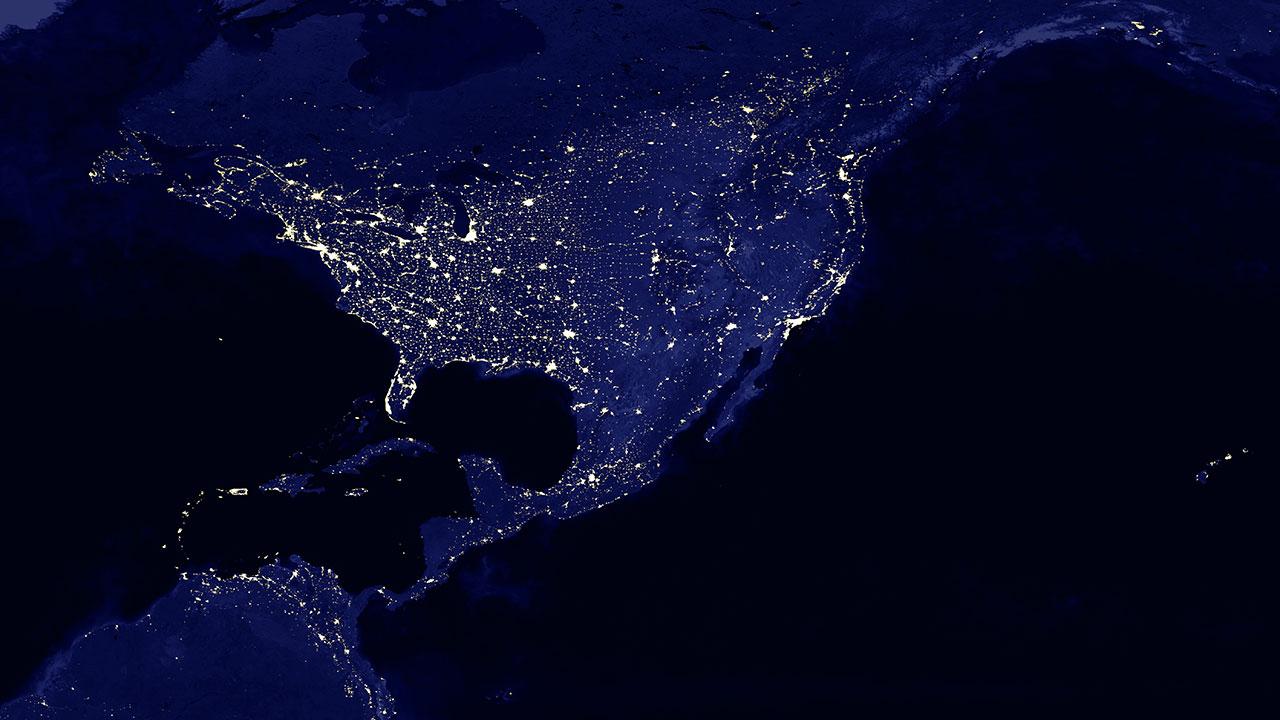 Grid reliability represented by blue image taken from space of North America at night with lights crisscrossing the land
