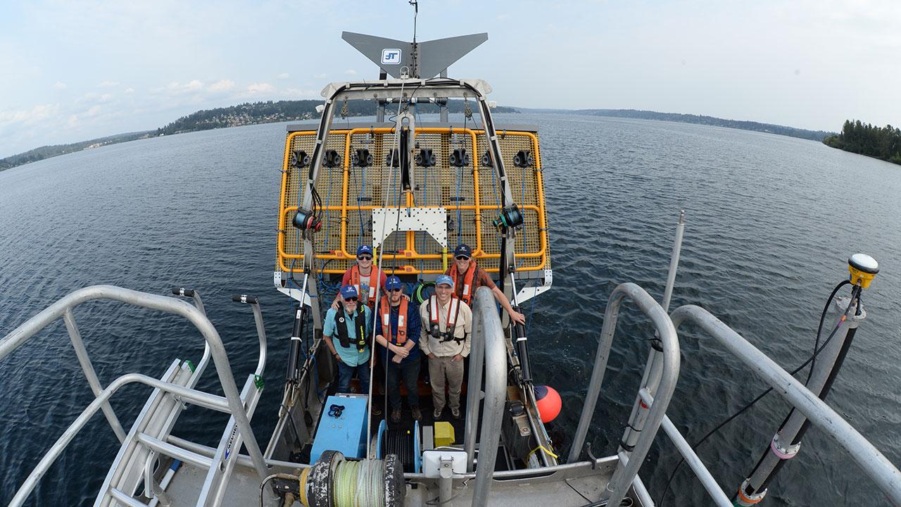 Five Tetra Tech bathymetric survey crew members pose with Ultra TEMA-4 for detection of under水 munitions and unexploded ordnance