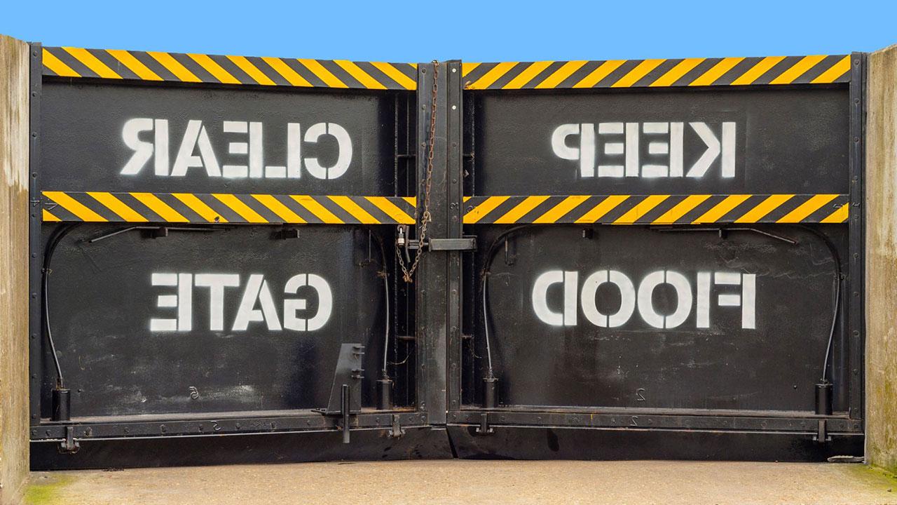 Closed flood gates with “Keep Clear – Flood Gate” painted in white