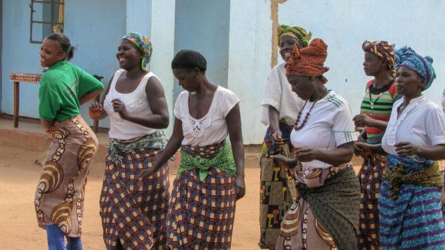 Members of community dance troop and Chipata District Land facilitator, Misozi Banda celebrate land certificates